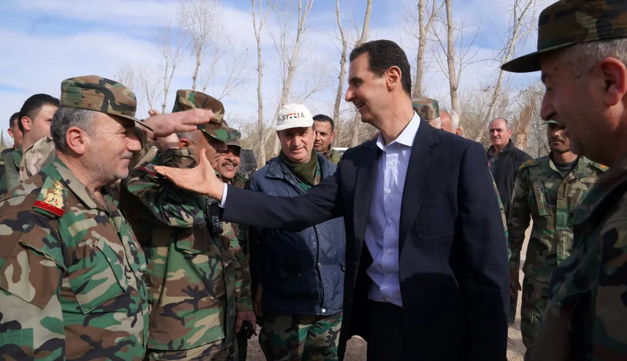 Gambar yang dirilis pada Minggu (18/3), menunjukkan Presiden Suriah Bashar al-Assad mengunjungi pasukan pemerintah di garis depan wilayah Ghouta Timur. Kunjungan dilakukan saat perang di Suriah memasuki tahun ke-8. (HO/SYRIAN PRESIDENCY FACEBOOK PAGE/AFP)