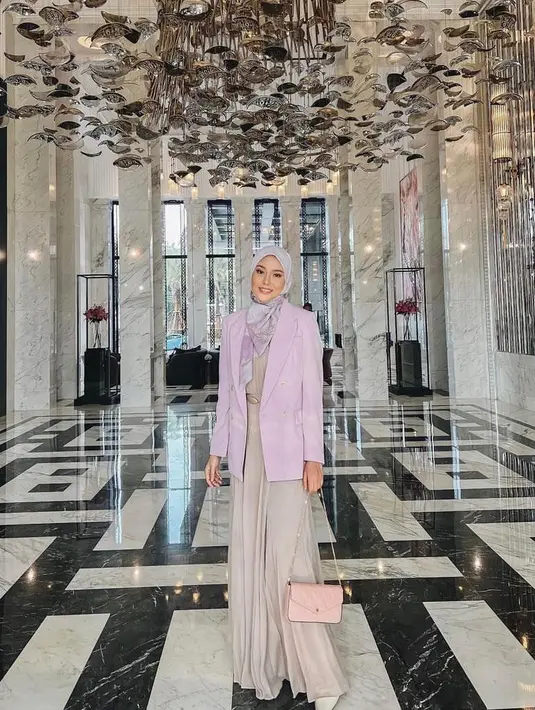 Ciptakan tampilan formal yang modis dengan padu padan gamis nuansa warna nude dengan blazer warna pink dan hijab warna abu-abu seperti potret Dara yang satu ini. (Instagram/daraarafah).