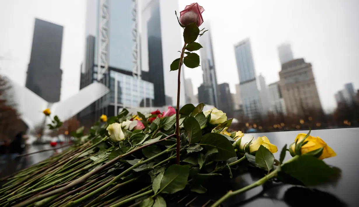 Orang-orang menaruh bunga mawar di atas nama korban pengeboman World Trade Center 1993 pada upacara peringatan “Tragedi 9/11” di New York, Rabu (26/2/2020). 27 tahun lalu teroris meledakkan bom di sebuah garasi parkir World Trade Center (WTC) yang menewaskan enam korban. (AP/John Minchillo)
