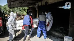 Petugas mengenakan APD saat proses kremasi jenazah pasien Covid-19 di Krematorium Cilincing, Jakarta Utara, Minggu (25/7/2021). Proses kremasi terbagi menjadi dua shift, yakni pagi untuk jenazah non-Covid-19 dan sore hari untuk jenazah pasien Covid-19. (merdeka.com/Iqbal S Nugroho)