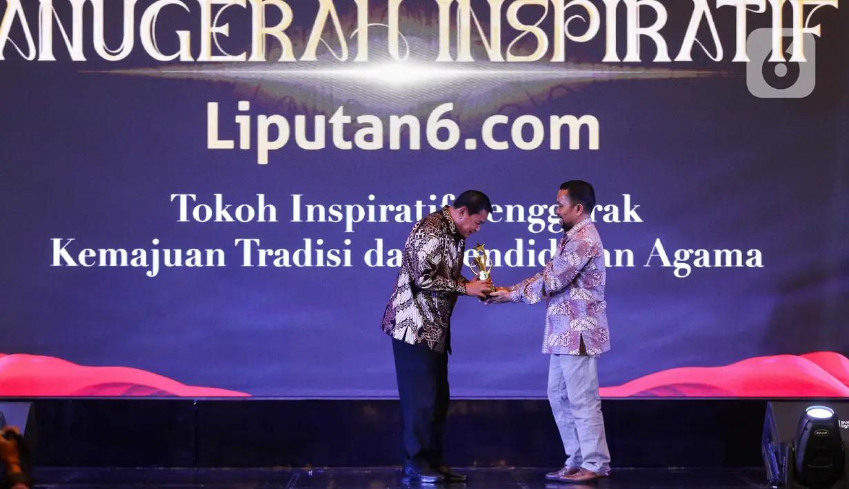 Chief Content Officer (COO) KapanLagi Youniverse, Wens Manggut (kanan) memberikan plakat kepada  Ketua LPTQ Kabupaten Tanggerang dan Sekretaris daerah Kabupaten Tanggerang periode 2017-2024 Mochamad Maesyal Rasyid saat acara Anugerah Inspiratif Liputan6.com di hotel Shangri La, Jakarta, Rabu (31/7/2024). Mochamad Maesyal Rasyid mendapatkan penghargaan Tokoh Inspiratif Penggerak Kemajuan Tradisi dan Pendidikan Agama. (Liputan6.com/Herman Zakharia)