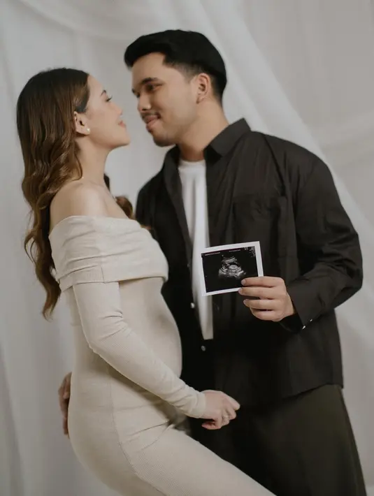 Thariq Halilintar tampil serasi mendampingi Aaliyah dengan outfit bernuansa earthy tone dari @aisehomme. Kemeja netral yang dipadukan dengan celana simpel menciptakan tampilan maskulin yang lembut, mempertegas harmoni visual pasangan ini.  [Foto: IG/@fordem.co].