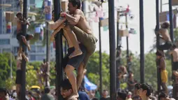 Dalam rangka menyemarakkan HUT ke-80 RI, Pantai Ancol menggelar perlombaan panjat pinang secara kolosal. (AP Photo/Tatan Syuflana)