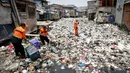 Petugas membersihkan sampah yang menumpuk di Kali Gendong, Penjaringan, Jakarta Utara, Kamis (16/3). Ceceran sampah plastik limbah rumah tangga terlihat menyerupai daratan menumpuk di sepanjang Kali Gendong. (Liputan6.com/Faizal Fanani)