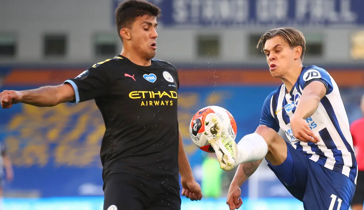 Gelandang Manchester City, Rodrigo berebut bola dengan pemain Brighton and Hove Albion, Leandro Trossard pada Pekan ke-35 Liga Inggris di stadion The American Express, Minggu (12/7/2020). Manchester City berpesta gol di markas Brighton. (Julian Finney/Pool via AP)