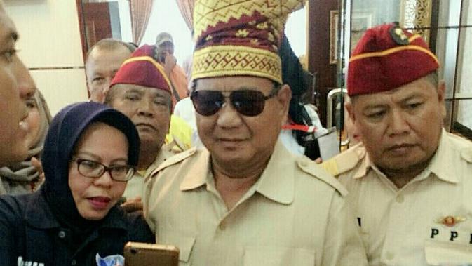 Prabowo asli diajak salah satu pendukungnya berfoto usai tiba di Bandara Pekanbaru. (Liputan6.com/M Syukur)