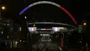 Sejumlah warga beraktifitas di sekitar Stadion Wembley yang dihiasi lampu berwarna bendera Prancis, Senin (16/11/2015). Lampu ini merupakan bentuk belasungkawa Inggris terhadap serangan terror di Paris. (Action Images via Reuters/Henry Browne)
