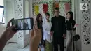 Pasangan Ririn  dan Zaenal berfoto bersama kerabat usai melangsungkan pernikahan di KUA Kecamatan Matraman, Jakarta, Selasa (22/02/2022). Sejumlah pasangan sengaja melangsungkan pernikahan pada hari ini yang memiliki tanggal, bulan, dan tahun unik yakni 22-02-2022. (Liputan6.com/Herman Zakharia)