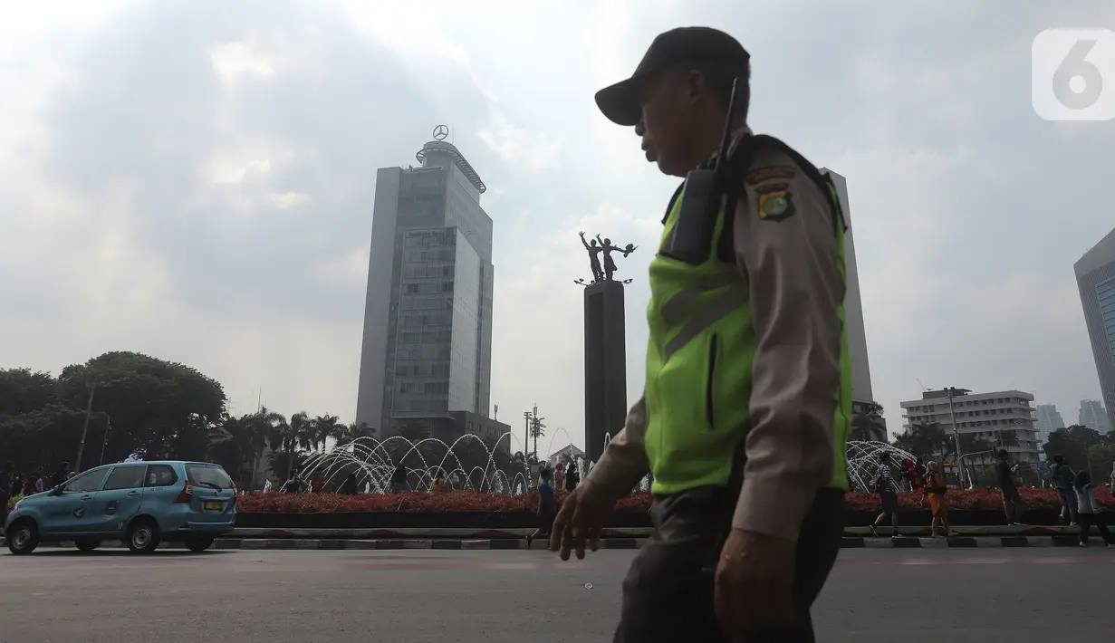 Petugas kepolisian berjaga di kawasan Bundaran HI, Jakarta, Minggu (20/10/2019). Car free day (CFD) ditiadakan Minggu (20/10) ini dalam rangka pelantikan Presiden dan Wapres periode 2019-2024, Joko Widodo dan Ma'aruf Amin di Kompleks Parlemen, Senayan, Jakarta. (Liputan6.com/Herman Zakharia)