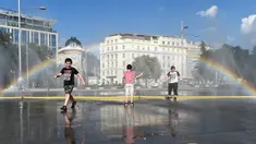 Anak-anak menyejukkan diri di dekat semprotan air di Schwarzenbergplatz di Wina, Austria (28/7/2020). Suhu tertinggi di Wina mencapai angka 37,2 derajat Celsius pada Selasa (28/7). (Xinhua/Guo Chen)