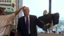Salah satu kru merapikan rambut kandidat calon presiden AS, Donald Trump usai diserang seekor burung elang botak saat sesi pengambilan foto di kantor Majalah TIME untuk nominasi dia sebagai Person of the Year, Kamis (10/12). (REUTERS/TIME Magazine)