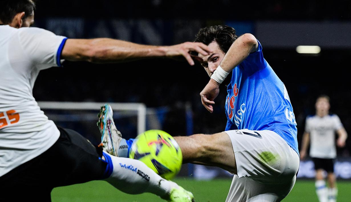 Striker Napoli, Khvicha Kvaratskhelia (kanan) berebut bola dengan bek Atalanta, Rafael Toloi pada laga pekan ke-26 Liga Italia 2022/2023 di Diego Armando Maradona Stadium, Naples, Minggu (12/3/2023) dini hari WIB. (AFP/Filippo Monteforte)