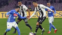 Striker Juventus, Cristiano Ronaldo, berusaha melewati pemain Napoli pada laga Serie A di Stadion San Paolo, Minggu (3/3). Juventus menang 2-1 atas Napoli. (AP/Ciro Fusco)