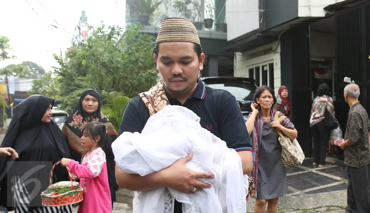 Presenter Indra Bekti menggendong jenazah anak ketiganya menuju TPU Kamboja, Radio Dalam,  Jakarta, Rabu (1/2). Anak ketiga pasangan Indra Bekti dan Aldilla Jelita itu meninggal beberapa menit setelah dilahirkan. (Liputan6.com/Herman Zakharia)
