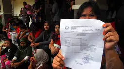 Seorang warga tampak menunjukkan surat keterangan tidak mampu sebagai syarat memperoleh KJP di Kantor Kelurahan Lenteng Agung, Jakarta, Rabu (4/6/14). (Liputan6.com/Miftahul Hayat)