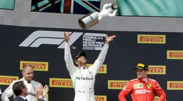 Pebalap Mercedes Lewis Hamilton (tengah) melemparkan trofi juara ke udara didampingi pebalap Mercedes Valtteri Bottas (kiri) dan pebalap Ferrari Charles Leclerc setelah menjuarai F1 GP Prancis 2019 di Sirkuit Paul Ricard, Minggu (23/6/2019). (AP Photo/Claude Paris)