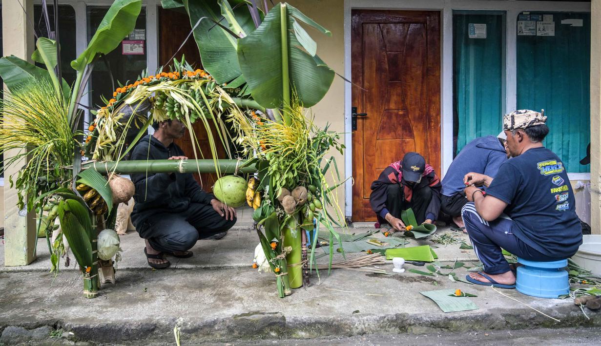 Warga desa menyiapkan persembahan sayuran dan buah-buahan menjelang upacara Yadnya Kasada di Ngadisari, di kaki Gunung Bromo, Jawa Timur, pada Minggu 31 Mei 2026. (JUNI KRISWANTO/AFP)