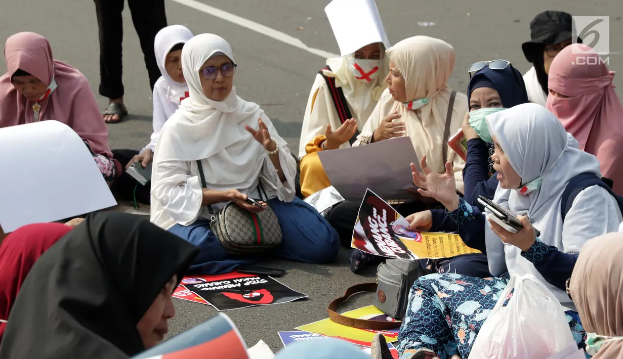 Massa berkumpul menyampaikan pendapat terkait sidang perselisihan hasil pilpres 2019 di sekitar Patung Arjuna Wiwaha Jalan Medan Merdeka Barat, Jakarta, Jumat (14/6/2019). Massa meminta sidang berlangsung adil. (Liputan6.com/Helmi Fithriansyah)