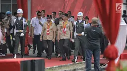 Presiden Joko Widodo didamping Ketua Kwarnas Pramuka Adhyaksa Dault tiba menghadiri perayaan hari jadi Pramuka yang ke-57 di Lapangan Gajah Mada, Wiladatika, Cibubur, Jakarta, Selasa (14/8). (Liputan6.com/Faizal Fanani)