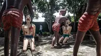 Seorang wanita berjalan di dekat patung-patung yang menggambarkan nasib orang-orang yang melakukan perbuatan buruk di taman yang menggambarkan neraka versi Buddha di kuil Wat Saeng Suk di provinsi pantai Thailand Chonburi (9/7/2020). (AFP/Lillian Suwanrumpha)