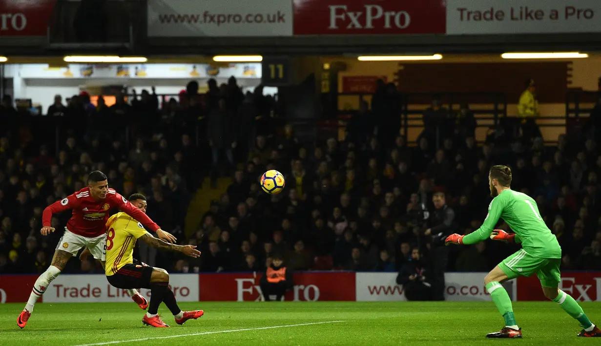 Striker Watford Andre Grey berebut bola dengan bek Manchester United, Marcos Rojo pada laga pekan ke-14 Premier League 2017-2018 di Vicarage Arena, Selasa (28/11). MU sukses mempermalukan Watford dengan skor 4-2. (Glyn KIRK / AFP)