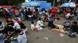 Pengunjung menikmati makan sambil lesehan jelang Closing Ceremony Asian Games 2018 di kawasan Gelora Bung Karno, Jakarta, Minggu (2/9). Kursi yang penuh menyebabkan mereka duduk lesehan. (Liputan6.com/Fery Pradolo)