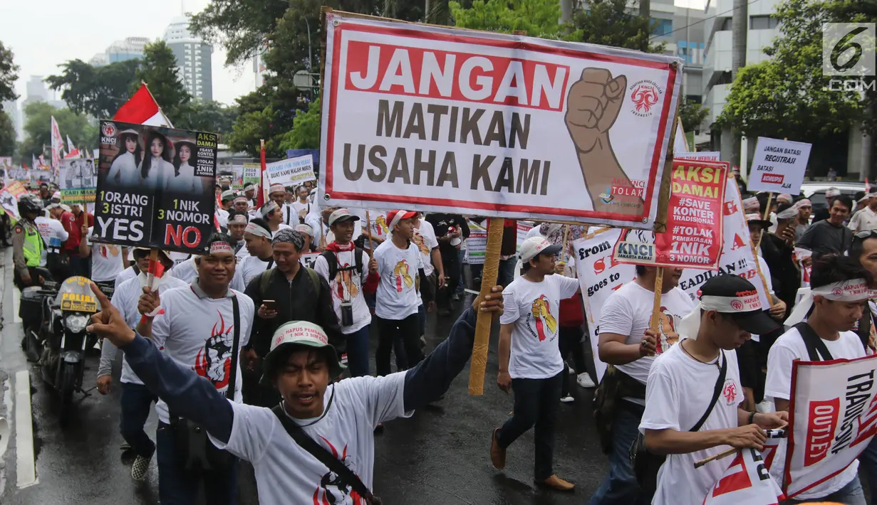 Pedagang pulsa membawa sejumlah spanduk saat menggeruduk Kantor Kementerian Komunikasi dan Informasi (Kemenkominfo), Jakarta, Senin (2/4). Mereka tergabung dalam Kesatuan Niaga Celluler Indonesia (KNCI). (Liputan6.com/Arya Manggala)