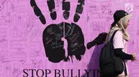 Warga melintas di depan banner tanda tangan dukungan Stop Bullying saat Car Free Day di Bundaran HI, Jakarta, Minggu (13/5). Bullying adalah tindakan mencoba untuk menyakiti atau mengontrol orang lain dengan kekerasan. (Liputan6.com/Helmi Fithriansyah)