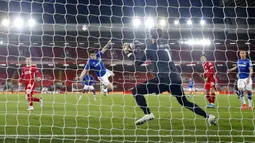 Pemain Everton Seamus Coleman melompat ke udara saat sundulannya diselamatkan oleh kiper Liverpool Alisson pada pertandingan Liga Inggris di Anfield, Liverpool, Inggris, Sabtu (20/2/2021). Liverpool kalah 0-2. (Phil Noble/Pool via AP)