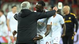 Pemain AS Roma, Tammy Abraham (kanan), memeluk Jose Mourinho setelah berhasil menahan imbang Bayer Leverkusen dengan skor 0-0 (agregat 1-0) di BayArena, Jumat (19/05/2023) dini hari WIB. The Special One girang bukan kepalang telah berhasil membawa AS Roma dua musim berturut-turut tampil di final kompetisi Eropa. (AFP/Ina Fassbender)