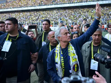 Pelatih baru klub Turki Fenerbahce, Jose Mourinho (tengah) melambaikan tangan saat memberikan sambutan kepada para suporter di Stadion Sukru Saracoglu, Istanbul, 2 Juni 2024. (Yasin AKGUL/AFP)