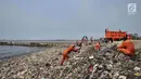 Petugas membersihkan sampah di pesisir Cilincing, Jakarta, Rabu (28/3). Menurut warga, hamparan sampah tersebut telah memenuhi pesisir Cilincing sejak puluhan tahun lalu hingga kini menjadi daratan yang dapat dilintasi. (Merdeka.com/Iqbal S. Nugroho)