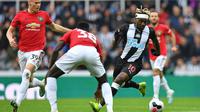 Gelandang Newcastle, Allan Saint-Maximin, berusaha melewati kepungan pemain Manchester United pada laga Premier League di Stadion St James Park, Newcastle, Minggu (6/10). Newcastle menang 1-0 atas MU. (AFP/Paul Ellis)