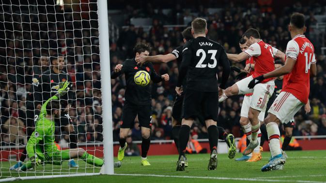 Pemain Arsenal Sokratis Papastathopoulos (kedua kanan) saat mencetak gol ke gawang Manchester United pada pertandingan lanjutan Liga Inggris di Emirates Stadium, London, Rabu (1/1/2020). Arsenal menang 2-0. (AP Photo/Matt Dunham)