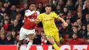 Duel antara Alex Iwoby dan Aleksey Rios pada leg 2, babak 16 besar Liga Europa yang berlangsung di stadion Emirates, London, Jumat (22/2). Arsenal menang 3-0 atas Bate Borisov. (AFP/Glyn Kirk)