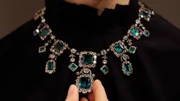 Model mengenakan kalung berlian berhias zamrud abad ke-19 di balai lelang Christie, London, Inggris, Selasa (9/4). Kalung yang ditaksir berharga Rp 21-35 M ini akan dilelang di Geneva Magnificent Jewels pada 15 Mei mendatang. (AP Photo/Kirsty Wigglesworth)