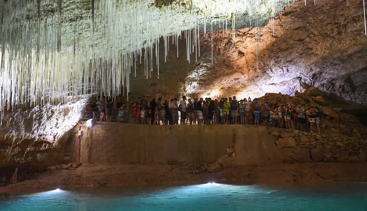 Pengunjung berada di dalam gua alam Choranche, di wilayah Vercors dekat Grenoble, Prancis (3/8). Sejak dimulainya gelombang panas, telah terjadi peningkatan setidaknya 10 persen jumlah pengunjung gua. (AFP Photo/Jean-Pierre Clatot)