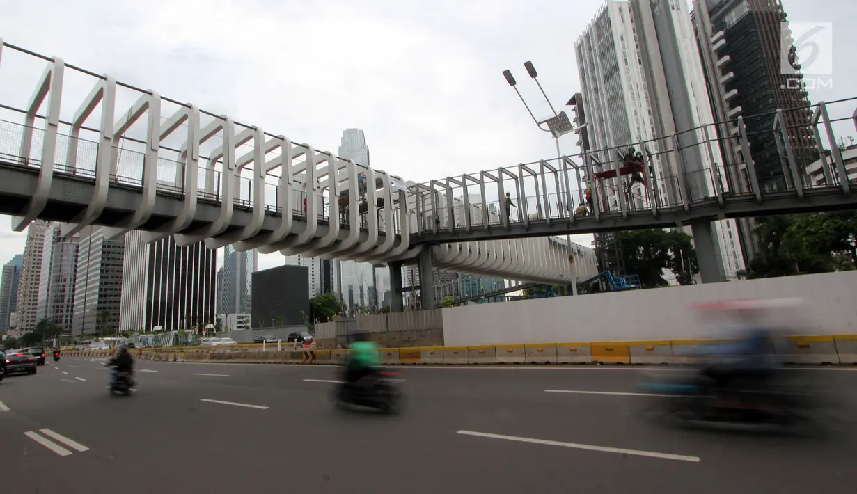 Pekerja melakukan pengerjaan revitalisasi Jembatan Penyeberangan Orang (JPO) Ratu Plaza, Jakarta, Jumat (28/12). JPO Ratu Plaza masuk dalam proses revitalisasi dan ditargetkan selesai pada akhir Desember 2018. (Liputan6.com/JohanTallo)