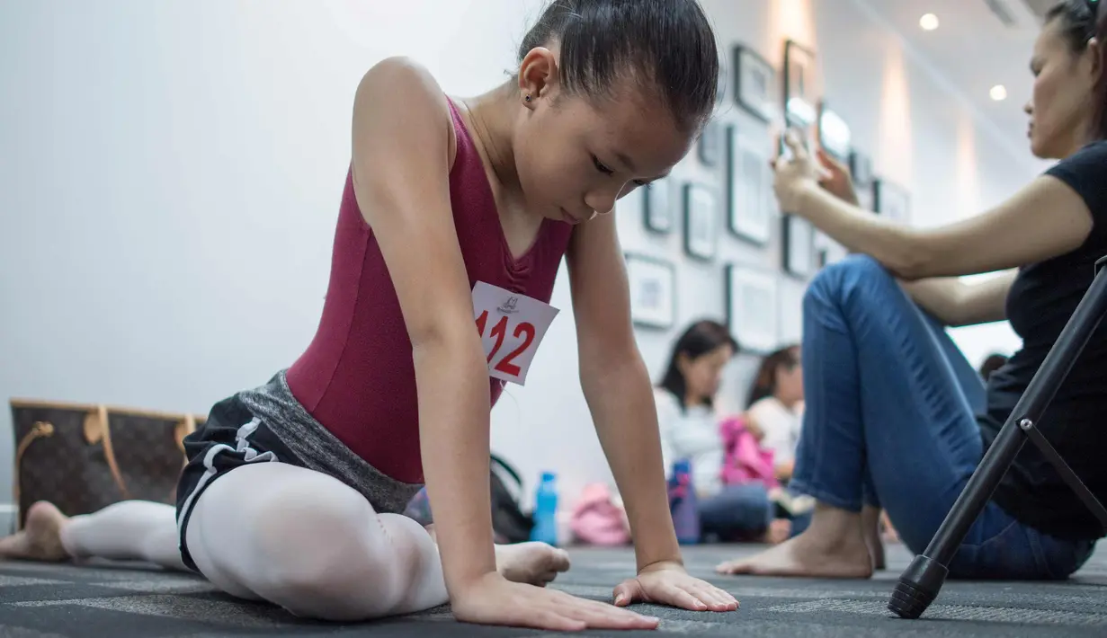 Pebalet muda melenturkan kakinya saat berlatih jelang kompetisi Balet Malaysia yang akan datang di Kuala Lumpur (28/11). Kompetisi balet ini akan berlangsung pada 30 November. (AFP Photo/Mohd Rasfan)