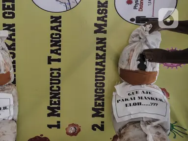 Pekerja memasang boneka pocong di Kantor Kecamatan Senen, Jakarta, Kamis (13/8/2020). Pemkot Jakpus menyiapkan peti mati dan boneka pocong untuk dipajang di setiap kecamatan sebagai peringatan akan bahaya Covid-19 dan imbauan untuk tidak mengabaikan protokol kesehatan. (merdeka.com/Iqbal Nugroho)
