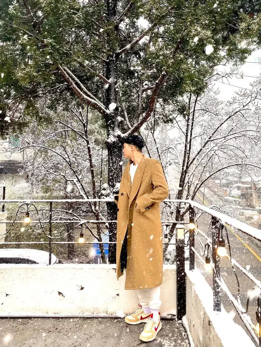 Di tengah salju, Park Seo Joon berpose. Mengenakan kaus putih yang kemudian ditumpuk long coat berwarna cokelat, Park Seo Joon memadukan penampilannya dengan jooger pants putih, dan sneakers favoritnya. Foto: Instagram.