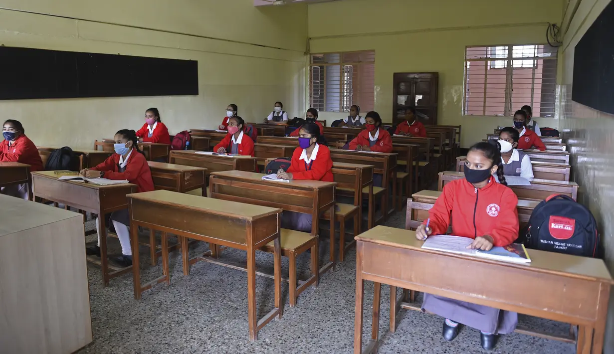 Suasana kegiatan belajar mengajar di kelas saat sekolah dibuka kembali setelah ditutup hampir sembilan bulan karena pandemi COVID-19 di Ahmedabad, India, Senin (11/1/2021). Negara bagian Gujarat telah membuka kembali sekolah hanya untuk kelas 10 dan 12. (Sam PANTHAKY / AFP)