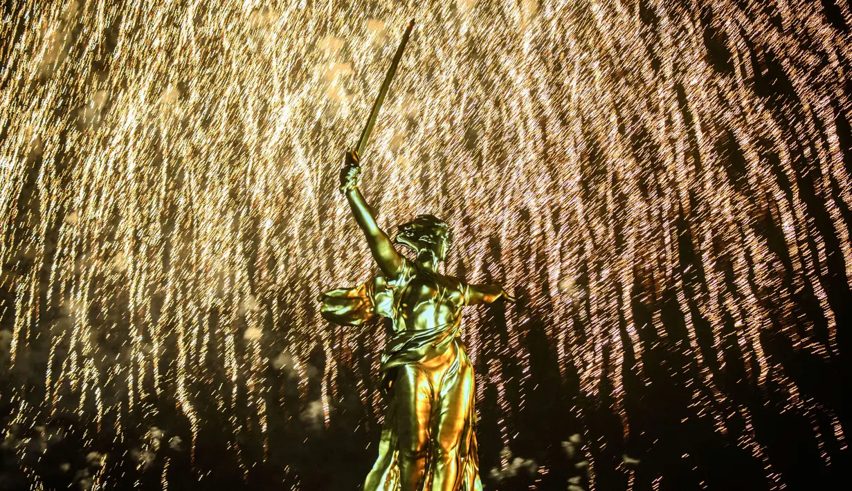 Patung The Motherland Calls dihiasi kembang api saat perayaan 73 tahun kemenangan Rusia dalam Perang Dunia II di Volgograd (8/5). Peringatan ini digelar setiap tahunnya. (AFP/Mladen Antonov)