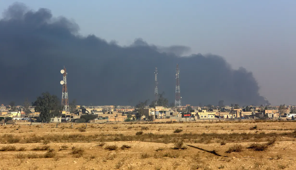 Kepulan asap hitam dari lokasi pabrik kimia yang dibakar ISIS di Qayyara, Irak, (12/11). (REUTERS/Air Jalal)