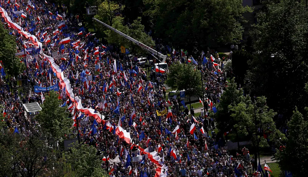 Ribuan warga turun ke jalan memprotes pemerintahan baru Polandia yang dipegang oleh partai konservatif di Warsaw, Sabtu (7/5). Beramai-ramai, massa mengepung Ibu Kota guna menuntut perubahan hukum dan peradilan yang baru dibuat. (REUTERS/Kacper Pempel)