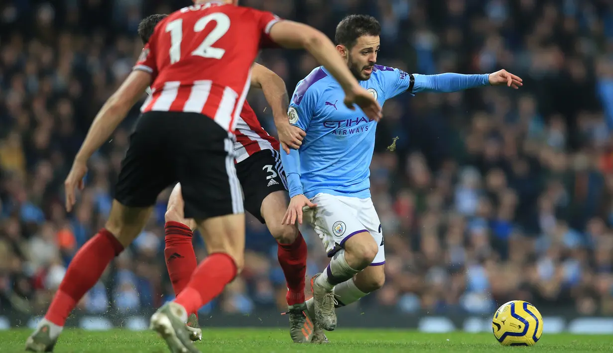 Gelandang Manchester City Bernardo Silva berebut bola dengan pemain Sheffield United Enda Stevens dan John Egan pada laga pekan ke-20 Liga Inggris di Etihad Stadium, Minggu (29/12/2019). Hasil manis dipetik Man City usai meraih kemenangan 2-0 saat menjamu Sheffield United. (Lindsey Parnaby / AFP)