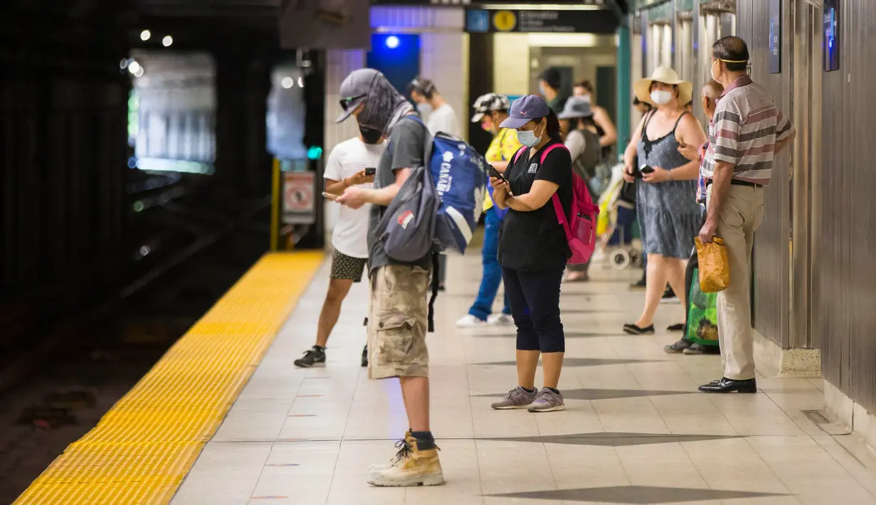 Para penumpang yang mengenakan masker menunggu kereta di sebuah stasiun kereta bawah tanah di Toronto, 2 Juli 2020. Toronto Transit Commission (TTC) mewajibkan para pengguna layanan kereta bawah tanah memakai masker atau penutup wajah mulai Kamis (2/7) karena pandemi COVID-19. (Xinhua/Zou Zheng)