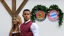 Gelandang Bayern Munchen, Thiago Alcantara bersama sang istri, Julia Vigas, mengenakan gaun tradisional Bavaria saat menikmati akhir dengan mengunjungi festival bir tahunan Oktoberfest di Munich, Jerman, Minggu (7/10). (Christof STACHE / AFP)