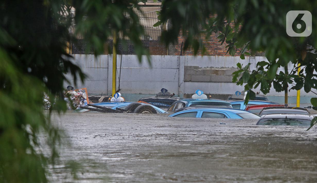 Kondisi Pool Blue Bird yang terendam banjir di kawasan Kramat Jati, Jakarta, Selasa (25/2/2020). Meluapnya Kali Cipinang membuat Pool Taksi Blue Bird yang berada tepat di samping kali ikut terdampak banjir. (Liputan6.com/Herman Zakharia)