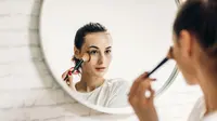 Ilustrasi perempuan mengaplikasikan makeup. (c) nazarpetryshak/Depositphotos.com